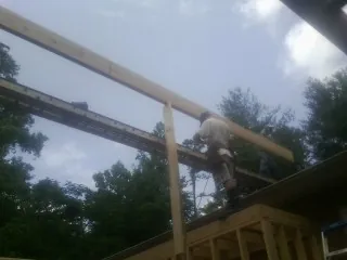 Carpenter setting a ridge beam over a new addition frame — Ice Dam Removal by Roofing Brothers in Hiddenite
