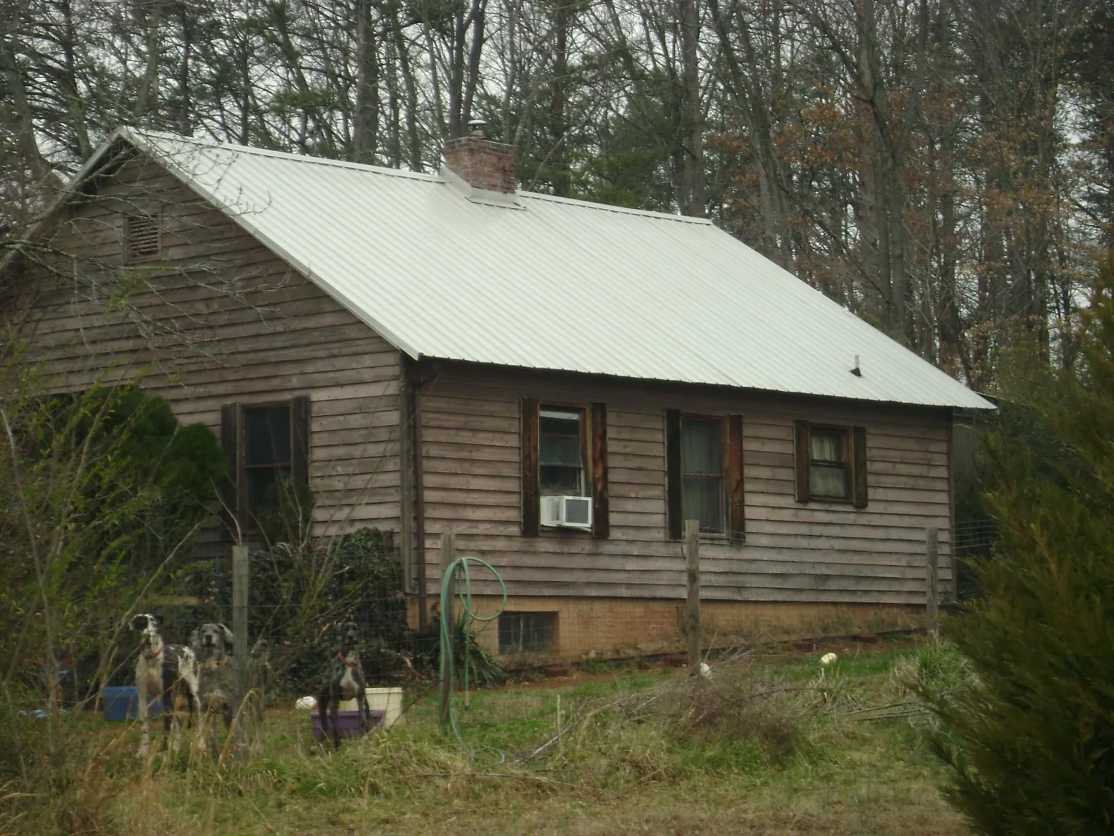 White metal roof on an old wood sided farmhouse, from a Metal Roof Installation job in Hiddenite